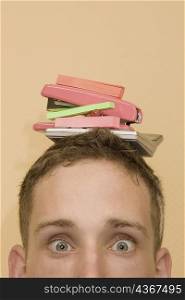 Portrait of a young man with stationery objects on his head