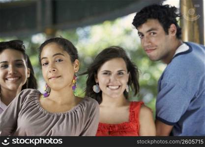 Portrait of a young man with three young women posing and smiling