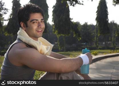 Portrait of a young man with towel round shoulders resting after sport activities