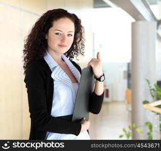 portrait of a young pretty woman standing inside office building