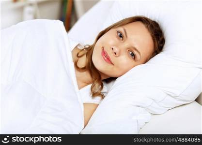 Portrait of a young smiling girl in bed