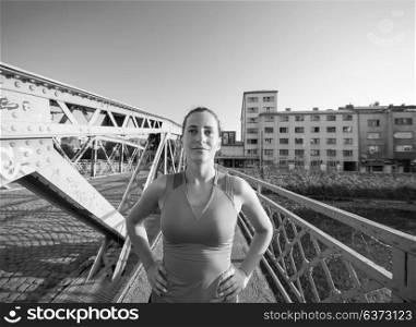 portrait of a young sporty jogging woman at sunny morning in the city