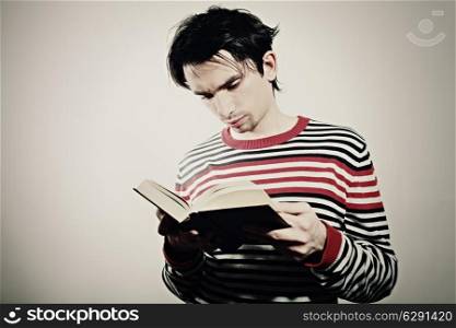 Portrait of a young student reading a textbook