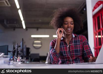 portrait of a young successful African American beautiful woman who enjoys spending a quality and joyful time while working in a large modern office