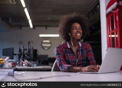 portrait of a young successful African American beautiful woman who enjoys spending a quality and joyful time while working in a large modern office