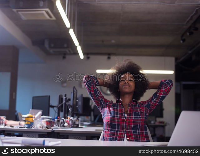 portrait of a young successful African American beautiful woman who enjoys spending a quality and joyful time while working in a large modern office