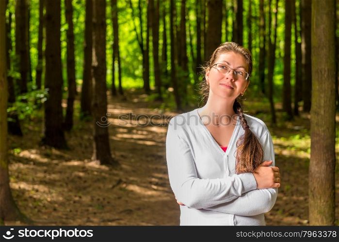 Portrait of a young thoughtful woman with glasses in forest