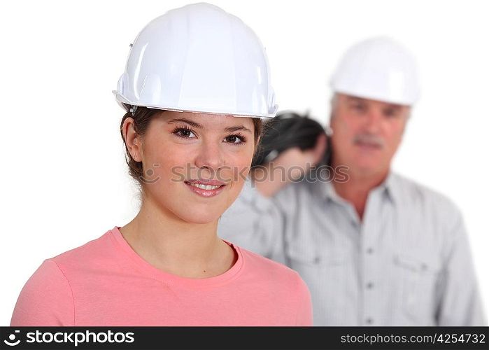 Portrait of a young tradeswoman with her boss in the background