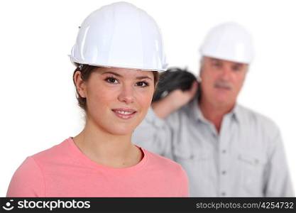 Portrait of a young tradeswoman with her boss in the background