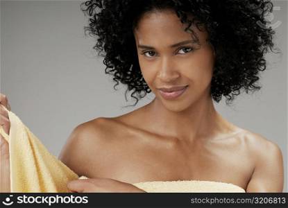 Portrait of a young woman adjusting a towel