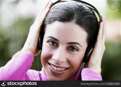 Portrait of a young woman adjusting headphones