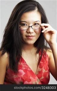 Portrait of a young woman adjusting her eyeglasses