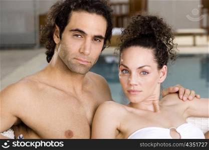 Portrait of a young woman and a mid adult man at the poolside