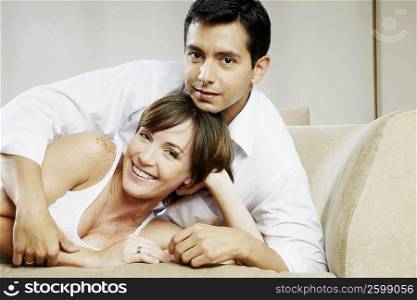 Portrait of a young woman and a mid adult man lying on a couch