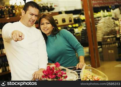 Portrait of a young woman and a mid adult man standing in a supermarket