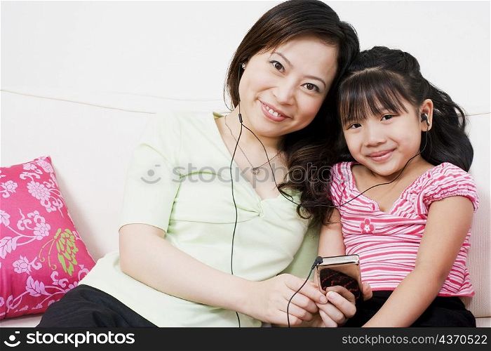 Portrait of a young woman and her daughter listening to an MP3 player