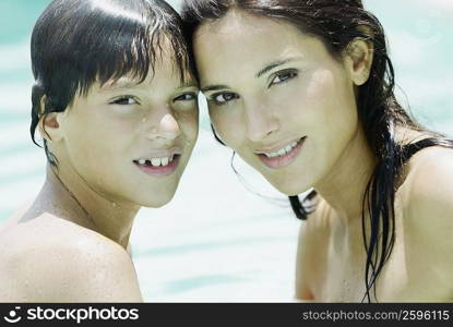 Portrait of a young woman and her son smiling in a swimming pool