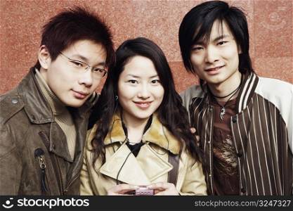 Portrait of a young woman and two young men smiling