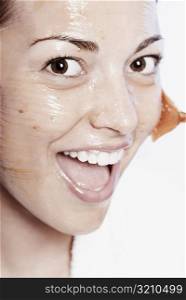 Portrait of a young woman applying a facial mask