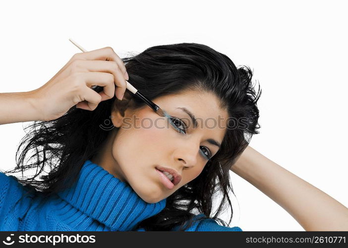 Portrait of a young woman applying eye shadow