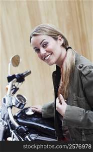 Portrait of a young woman beside a motorcycle