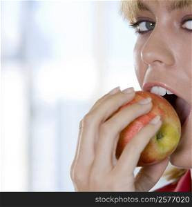Portrait of a young woman biting an apple