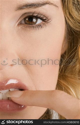 Portrait of a young woman biting her nail