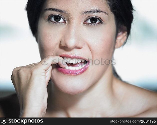 Portrait of a young woman biting her nails