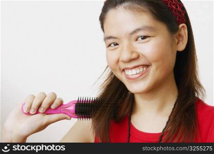 Portrait of a young woman brushing her hair and smiling