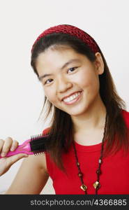 Portrait of a young woman brushing her hair and smiling