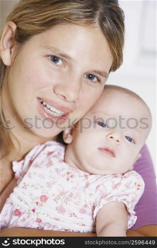 Portrait of a young woman carrying her baby girl