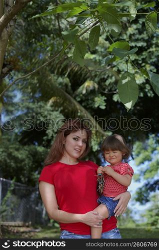 Portrait of a young woman carrying her daughter
