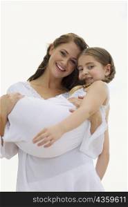 Portrait of a young woman carrying her daughter and smiling