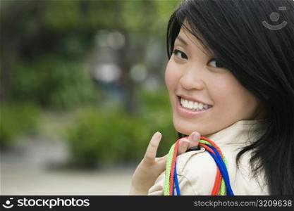 Portrait of a young woman carrying shopping bags and smiling