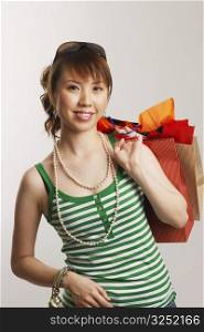 Portrait of a young woman carrying shopping bags and smiling