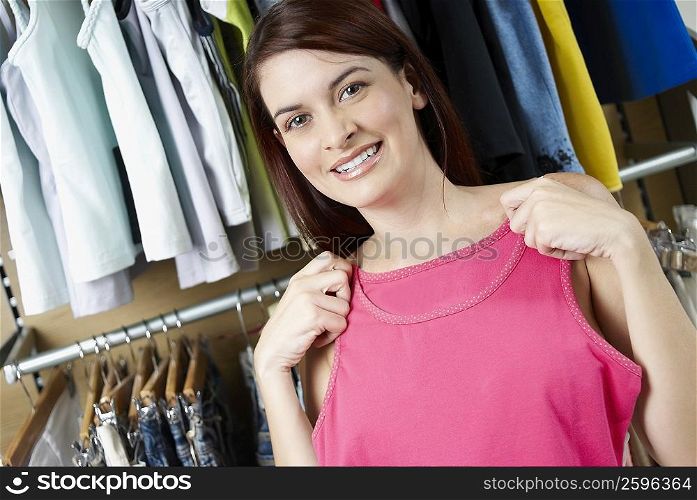 Portrait of a young woman choosing a top at a clothing store