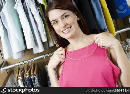 Portrait of a young woman choosing a top at a clothing store