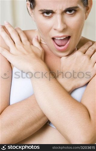 Portrait of a young woman covering her breast with her hands