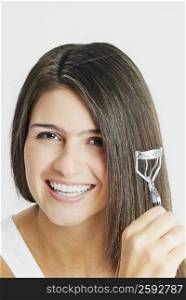 Portrait of a young woman crimping her hair