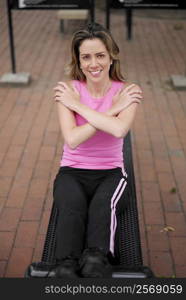 Portrait of a young woman doing sit-ups on a weight bench