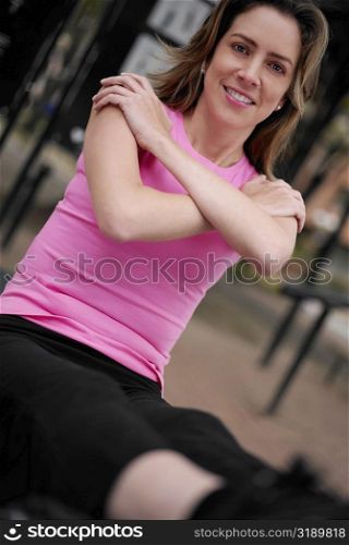Portrait of a young woman doing sit-ups with her arms crossed