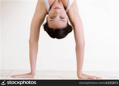 Portrait of a young woman doing the handstand