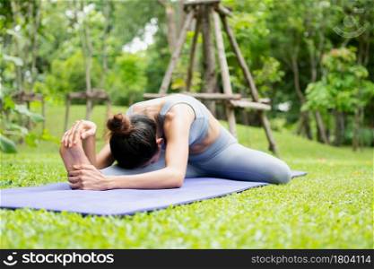 Portrait of a young woman doing yoga in the garden for a workout. Concept of lifestyle fitness and healthy. Asian women are practicing yoga in the park.