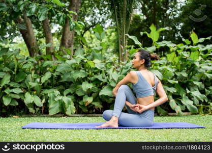 Portrait of a young woman doing yoga in the garden for a workout. Concept of lifestyle fitness and healthy. Asian women are practicing yoga in the park.