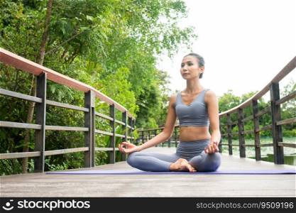 Portrait of a young woman doing yoga in the garden for a workout. Concept of lifestyle fitness and healthy. Asian women are practicing yoga in the park.