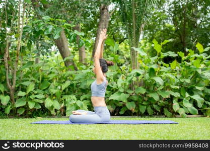 Portrait of a young woman doing yoga in the garden for a workout. Concept of lifestyle fitness and healthy. Asian women are practicing yoga in the park.