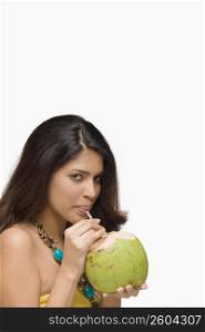 Portrait of a young woman drinking coconut milk