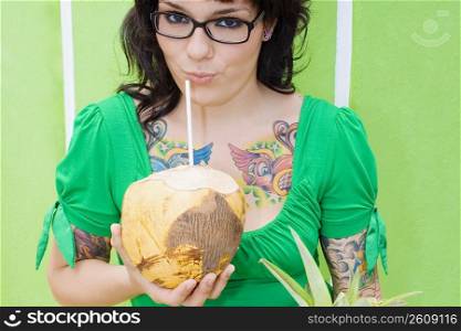 Portrait of a young woman drinking coconut milk with a drinking straw