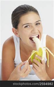 Portrait of a young woman eating a banana