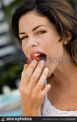 Portrait of a young woman eating a cupcake